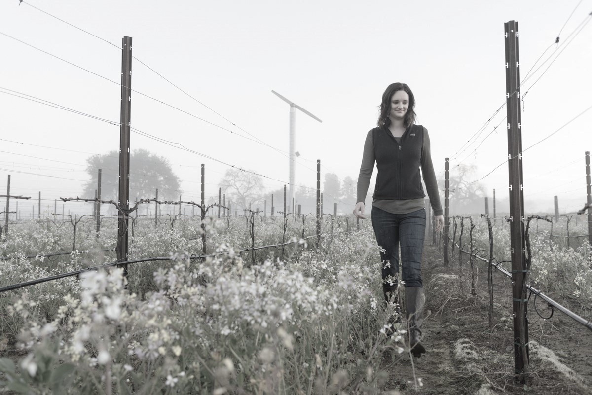 Melissa Castro walking through the Cabernet Sauvignon vines of the Spring Mountain District Vineyard on an overcast day during the winter.